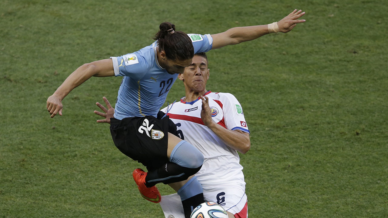 Uruguay’s Martin Caceres, left, and Costa Rica’s Oscar Duarte challenge for the ball during their Group D World Cup match in Fortaleza, Saturday, June 14, 2014.
