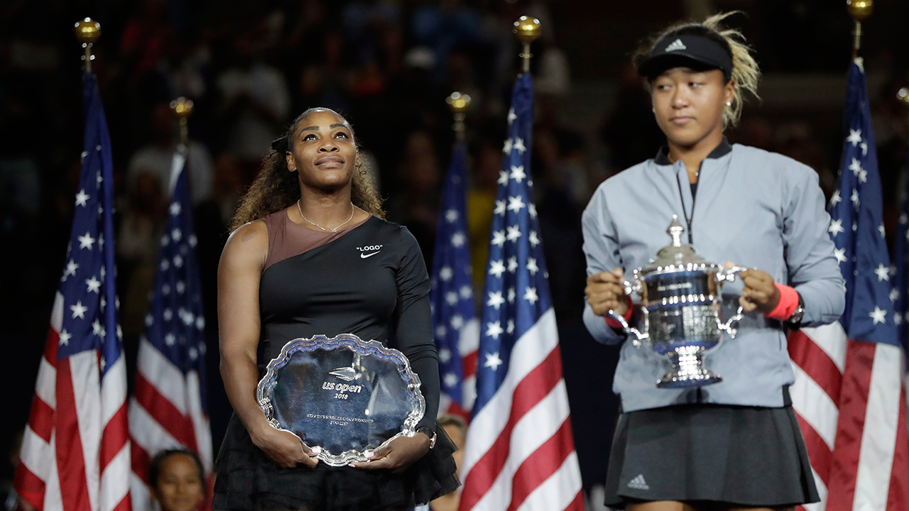serena-williams-watches-as-naomi-osaka-holds-us-open-trophy.jpg